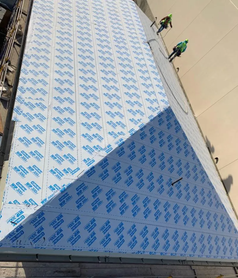 Professional roofers installing underlayment on a metal roof in West Ocean City